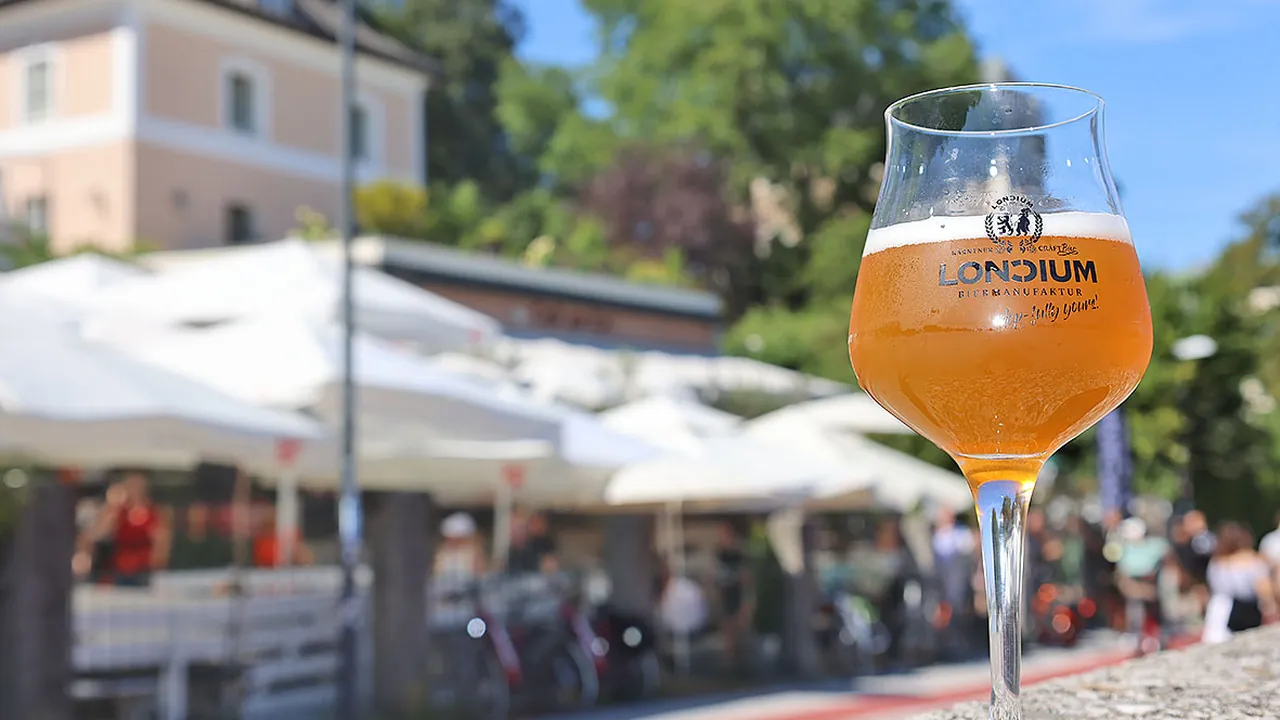 Frisch gezapftes Bier im Tastingglas vor einem Gastgarten